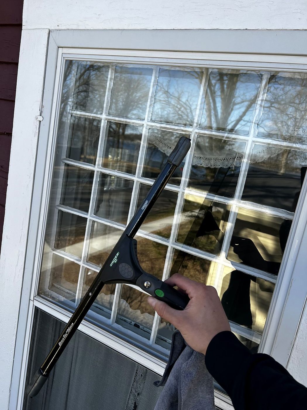 Squeegee cleaning a divided-light window, Barron County, WI