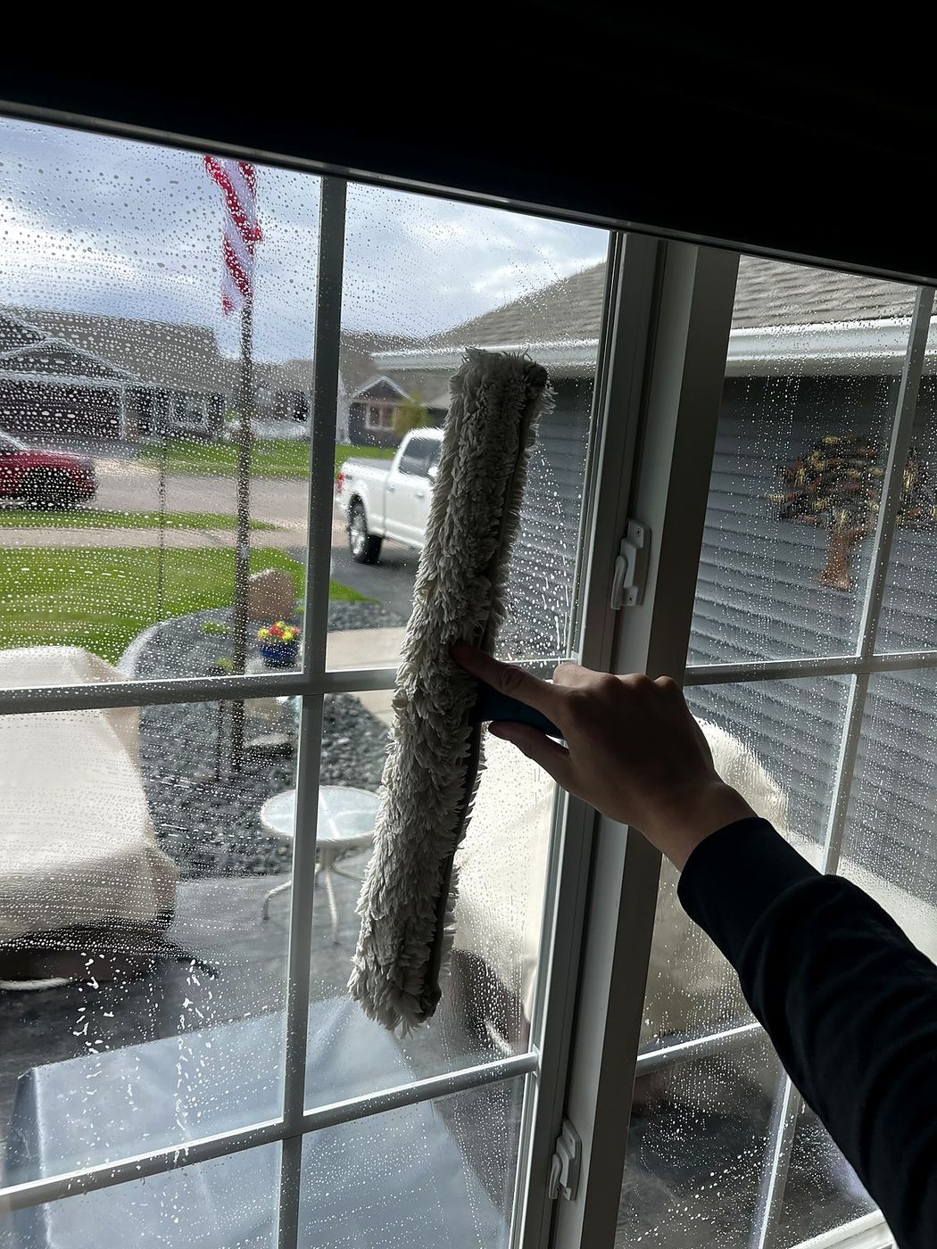 Window scrubber washing residential glass in Rice Lake, WI